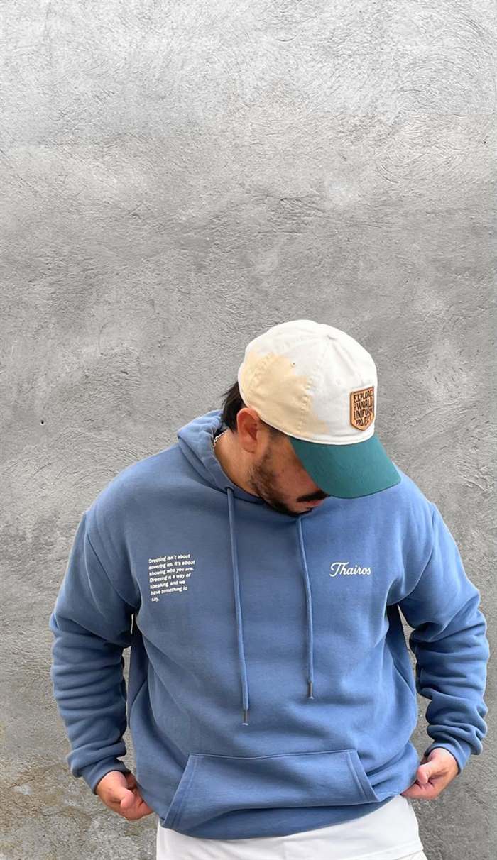 Frente del hoodie celeste, con la firma Thairos al pecho.